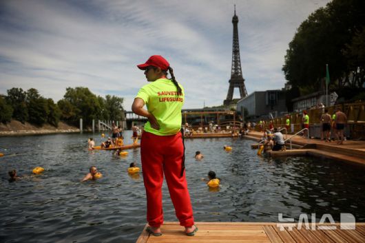 [파리=AP/뉴시스] 5일(현지 시간) 프랑스 파리 센 강에서 시민들이 수영을 하고 있는 가운데 안전요원이 배치돼 있다. 센 강은 100여 년 만에 공공 수영 공간으로 개방됐다. 마리 수로, 베르시 강변, 그르넬 항구 근처 등 세 곳이 야외 수영 구역으로 지정됐으며 오는 8월 31일까지 무료로 개방된다. 탈의실, 샤워 시설, 파라솔, 비치체어 등이 갖춰졌다. 2025.07.07.