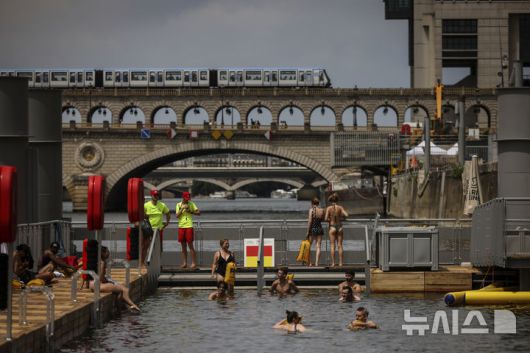 [파리=AP/뉴시스] 5일(현지 시간) 프랑스 파리 센 강 베르시에서 시민들이 수영을 하고 있다. 센 강은 100여 년 만에 공공 수영 공간으로 개방됐다. 마리 수로, 베르시 강변, 그르넬 항구 근처 등 세 곳이 야외 수영 구역으로 지정됐으며 오는 8월 31일까지 무료로 개방된다. 탈의실, 샤워 시설, 파라솔, 비치체어 등이 갖춰졌다. 2025.07.07.