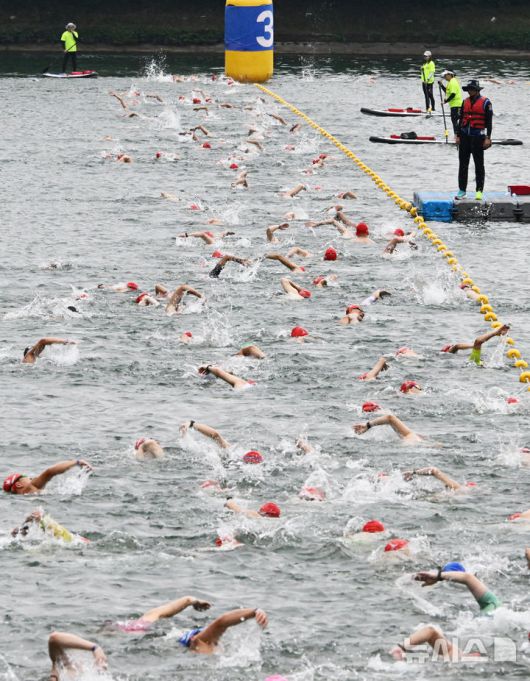 [서울=뉴시스] 김근수 기자 = 6일 오전 서울 송파구 롯데월드타워 일대에서 열린 '2025 롯데 아쿠아슬론'에서 참가자들이 수영을 하고 있다. 철인 3종 경기에서 사이클론을 제외한 오픈워터 수영과 마라톤을 함께 겨루는 '2024 롯데 아쿠아슬론'은 석촌호수 두 바퀴(총 1.5Km)를 완영 후, 롯데월드타워 1층부터 123층까지 2,917개의 계단을 오르는 수직 마라톤 스카이런(SKY RUN)으로 진행됐다.(공동취재) 2025.07.06. photo@newsis.com