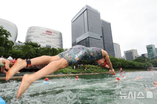 [서울=뉴시스] 김근수 기자 = 6일 오전 서울 송파구 롯데월드타워 일대에서 열린 '2025 롯데 아쿠아슬론'에서 참가자들이 수영을 하고 있다. 철인 3종 경기에서 사이클론을 제외한 오픈워터 수영과 마라톤을 함께 겨루는 '2024 롯데 아쿠아슬론'은 석촌호수 두 바퀴(총 1.5Km)를 완영 후, 롯데월드타워 1층부터 123층까지 2,917개의 계단을 오르는 수직 마라톤 스카이런(SKY RUN)으로 진행됐다.(공동취재) 2025.07.06. photo@newsis.com