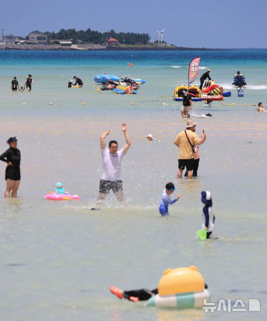 [제주=뉴시스] 우장호 기자 = 폭염의 기세가 수그러들지 않는 6일 오후 제주시 한림읍 금능해수욕장을 찾은 피서객들이 시원한 바닷물에 발을 담그며 더위를 식히고 있다. 2025.07.06. woo1223@newsis.com