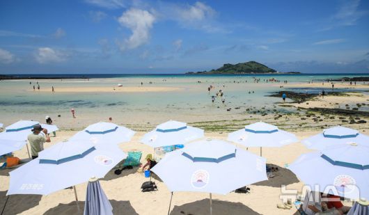 [제주=뉴시스] 우장호 기자 = 폭염의 기세가 수그러들지 않는 6일 오후 제주시 한림읍 금능해수욕장을 찾은 피서객들이 시원한 바닷물에 발을 담그며 더위를 식히고 있다. 2025.07.06. woo1223@newsis.com