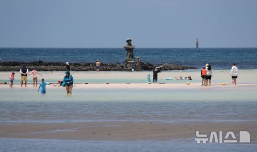 [제주=뉴시스] 우장호 기자 = 폭염의 기세가 수그러들지 않는 6일 오후 제주시 한림읍 금능해수욕장을 찾은 피서객들이 시원한 바닷물에 발을 담그며 더위를 식히고 있다. 2025.07.06. woo1223@newsis.com