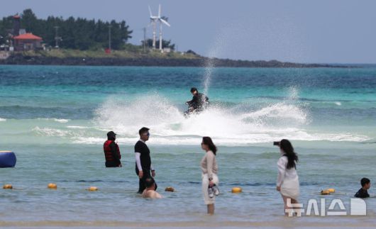 [제주=뉴시스] 우장호 기자 = 폭염의 기세가 수그러들지 않는 6일 오후 제주시 한림읍 금능해수욕장을 찾은 피서객들이 시원한 바닷물에 발을 담그며 더위를 식히고 있다. 2025.07.06. woo1223@newsis.com