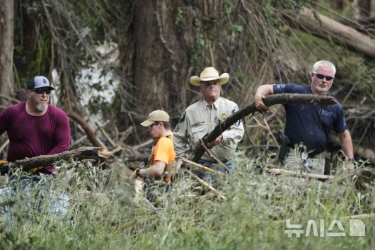 [센터 포인트=AP/뉴시스] 7일(현지 시간) 미 텍사스주 센터 포인트에서 경찰이 홍수 피해 복구를 돕고 있다. 텍사스주를 강타한 폭우와 홍수로 '캠프 미스틱'에 참가했던 어린이 중 27명이 숨지면서 사망자 수는 100명을 넘어선 것으로 알려졌다. 2025.07.08.
