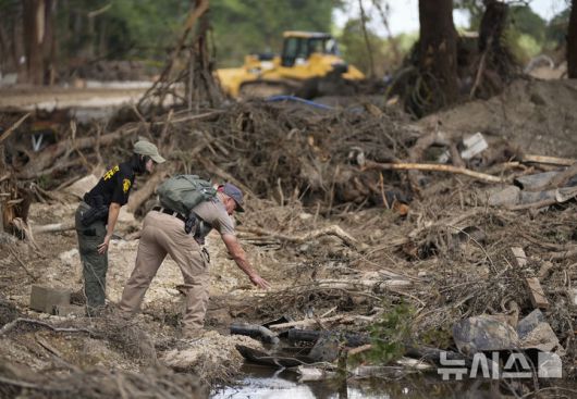 [텍사스=AP/뉴시스] 8일(현지 시간) 미국 텍사스주 잉그램 과달루페 강 인근 홍수 피해 현장에서 업튼 카운티 보안관들이 실종자 수색 및 복구 작업을 하고 있다. 2025.07.09.