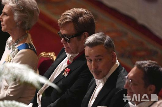 [윈저성(영국)=AP/뉴시스] 7월8일 영국의 찰스3세 국왕이 마련한 윈저성의 마크롱프랑스대통령 환영 만찬회에 참석한 가수 엘튼 존(왼쪽)과  데이비드 퍼니시영화감독. 2025. 07.09.