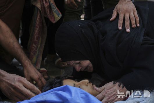 [누세이라트=AP/뉴시스] 13일(현지 시간) 가자지구 중부 누세이라트 알 아우다 병원에서 식수 배급 중 이스스라엘 군 공습으로 사망한 어린이의 가족들이 슬픔에 잠겨 있다. 2025.07.14.