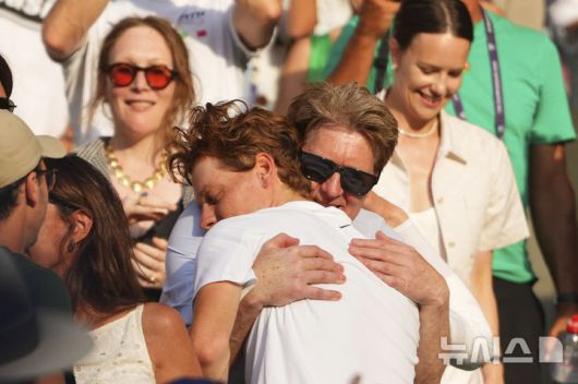 [런던=AP/뉴시스] 얀니크 신네르(1위·이탈리아)가 13일(현지 시간) 영국 런던 올잉글랜드 클럽에서 열린 2025 윔블던 테니스 대회 남자 단식 결승에서 카를로스 알카라스(2위·스페인)를 꺾고 우승한 후 응원석의 가족과 포옹하고 있다. 신네르는 3연패를 노리는 알카라스에게 3-1(4-6 6-4 6-4 6-4) 역전승을 거두고 윔블던 첫 우승을 차지했다. 2025.07.14.