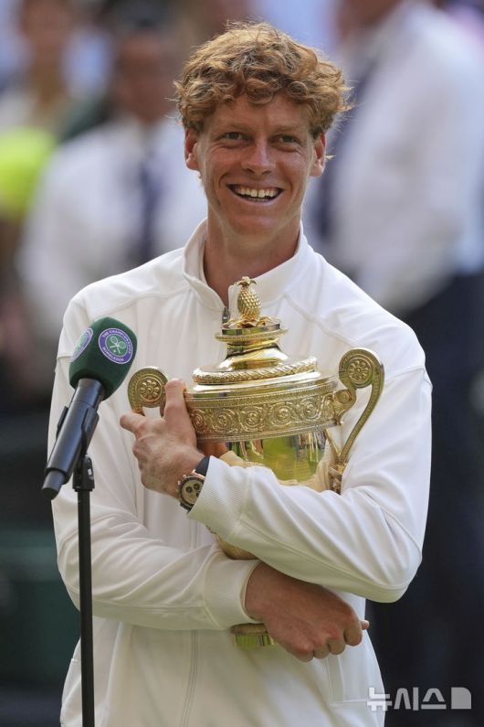 [런던=AP/뉴시스] 얀니크 신네르(1위·이탈리아)가 13일(현지 시간) 영국 런던 올잉글랜드 클럽에서 열린 2025 윔블던 테니스 대회 남자 단식 정상에 올라 트로피를 품에 안고 활짝 웃고 있다. 신네르는 결승에서 3연패를 노리는 카를로스 알카라스(2위·스페인)에게 3-1(4-6 6-4 6-4 6-4) 역전승을 거두고 윔블던 첫 우승을 차지했다. 2025.07.14.