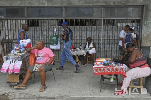 [하바나=AP/뉴시스] 15일(현지 시간) 쿠바 하바나의 한 국영 시설 입구에서 노점상들이 물건을 팔고 있다. 2025.07.16.