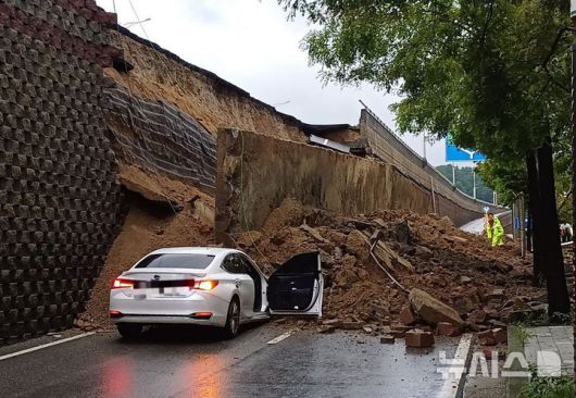 [오산=뉴시스] 김종택 기자 = 수도권 등 중부지역에 호우주의보가 발효된 16일 경기 오산시 가장교차로 옹벽이 도로로 무너져 차량을 덮치는 사고가 발생해 소방 당국이 대응 1단계를 발령, 구조작업을 벌이고 있다. (사진=경기도소방재난본부 제공) 2025.07.16. photo@newsis.com