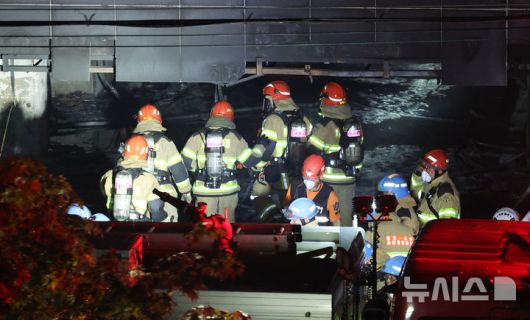 [광명=뉴시스] 황준선 기자 = 지난 17일 밤 경기 광명시 한 아파트 주차장에서 발생한 화재 현장에서 소방대원들이 이동하고 있다. 2025.07.18. hwang@newsis.com