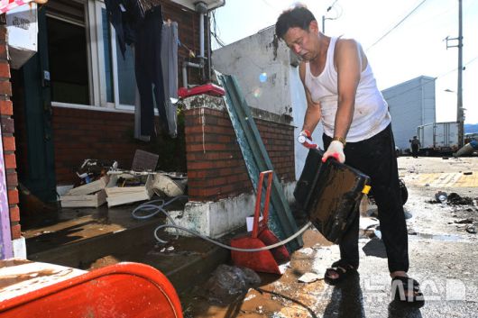 [광주=뉴시스] 이영주 기자 = 18일 오전 광주 북구 신안동에서 침수피해를 입은 주민이 집기를 씻어내고 있다. 광주에는 전날 하루 동안 426.4㎜의 비가 내리면서 1939년 기상관측 이후 광주지역 역대 최고 일강수량을 기록했다. 2025.07.18. leeyj2578@newsis.com
