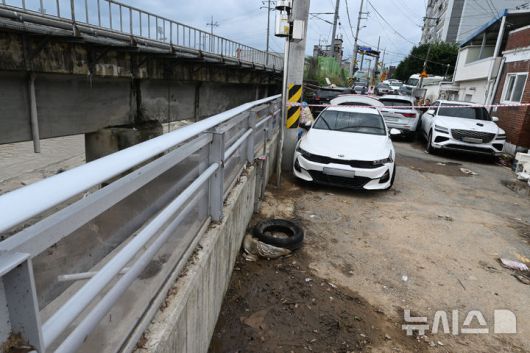 [광주=뉴시스] 이영주 기자 = 18일 광주 북구 신안동 서암대로 100번길 서방천 개수공사 과정에서 설치된 투명홍수방어벽 주변이 전날 내린 폭우로 어지럽혀져 있다. 주민들은 주변 서방천 범람을 막고자 지어진 홍수방어벽이 물그릇 역할을 하면서 침수 피해가 커졌다고 주장하고 있다. 광주지역에는 지난 17일 426㎜ 기록적 폭우가 내리면서 신안동 일대가 침수 피해를 입었다. 2025.07.18. leeyj2578@newsis.com