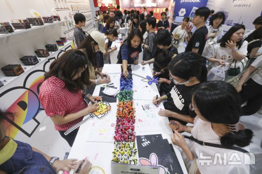 [서울=뉴시스] 김근수 기자 = 서울일러스트레이션페어V.19 2025 개막 첫 날인 24일 서울 강남구 코엑스에서 관람객들이 컬러펜으로 그림을 그리고 있다. 2024.07.24. ks@newsis.com