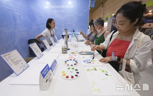 [서울=뉴시스] 김근수 기자 = 서울일러스트레이션페어V.19 2025 개막 첫 날인 24일 서울 강남구 코엑스에서 관람객들이 물감으로 그림을 그리고 있다. 2024.07.24. ks@newsis.com