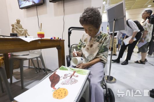 [서울=뉴시스] 김근수 기자 = 서울일러스트레이션페어V.19 2025 개막 첫 날인 24일 서울 강남구 코엑스에서 한 어르신 작가가 그림을 그리고 있다. 2024.07.24. ks@newsis.com