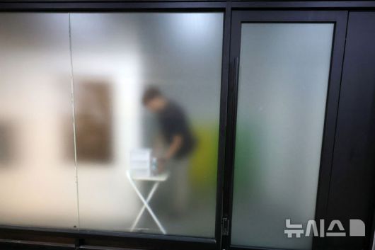 [서울=뉴시스] 조성우 기자 = 김건희 여사의 각종 의혹을 수사 중인 특별검사팀이 윤석열 전 대통령 부부의 자택과 코바나컨텐츠 사무실에 대해 압수수색에 착수한 25일 서울 서초구 아크로비스타 내 코바나컨텐츠 사무실에 관계자의 모습이 비치고 있다. 2025.07.25. xconfind@newsis.com