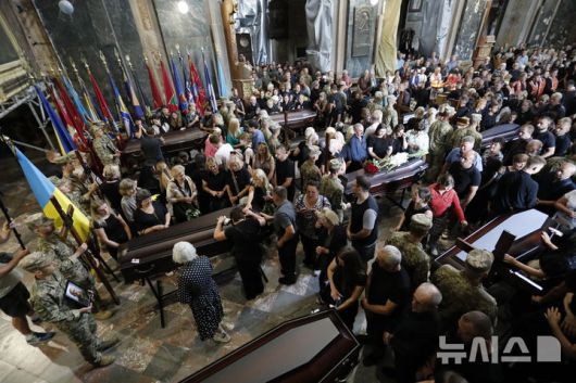 [리비우=AP/뉴시스] 지난 25일(현지 시간) 우크라이나 리비우에서 러시아 포로로 잡혀 숨진 군인 12명의 장례식을 거행되고 있다. 2025.07.27.