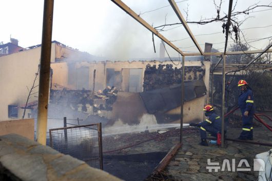 [ 아테네=AP/뉴시스] 그리스의 수도 아테네 북서부 교외의 크리요네리 지역에서 7월 26일 소방대원들이 한 주택으로 옮겨 붙은 산불의 진화작업을 하고 있다. 2025. 07.27.