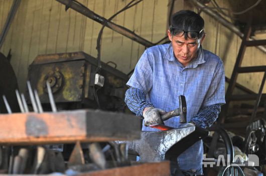 [광주=뉴시스] 이영주 기자 = 광주지역 최고기온이 37도까지 오른 29일 오후 광주 광산구 송정대장간에서 최종호(61) 송정대장간 대표가 망치와 모루를 이용해 약초를 캐는 도구를 만들고 있다. 광주지역에는 지난 20일 이후 현재까지 열흘 동안 폭염특보가 이어지고 있다. 2025.07.29. leeyj2578@newsis.com