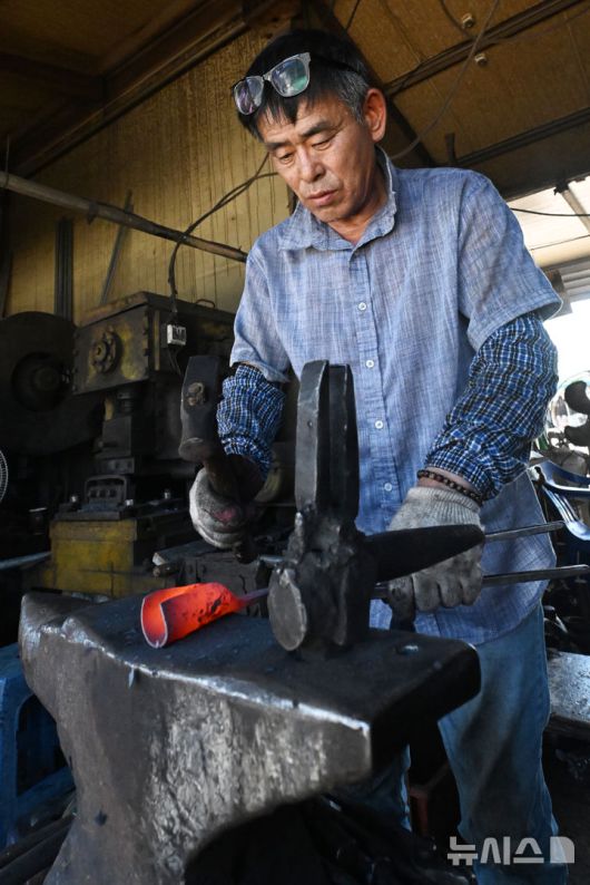 [광주=뉴시스] 이영주 기자 = 광주지역 최고기온이 37도까지 오른 29일 오후 광주 광산구 송정대장간에서 최종호(61) 송정대장간 대표가 망치와 모루를 이용해 약초를 캐는 도구를 만들고 있다. 광주지역에는 지난 20일 이후 현재까지 열흘 동안 폭염특보가 이어지고 있다. 2025.07.29. leeyj2578@newsis.com
