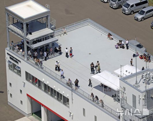 [홋카이도=AP·교도/뉴시스]30일 러시아 극동 캄차카 반도에서 강진이 발생해 일본 태평양 연안 지역들에 쓰나미 경보가 발령된 가운데, 경보가 내려진 홋카이도 무카와에서 소방서 옥상에 주민들이 대피해 있다. 2025.07.30.