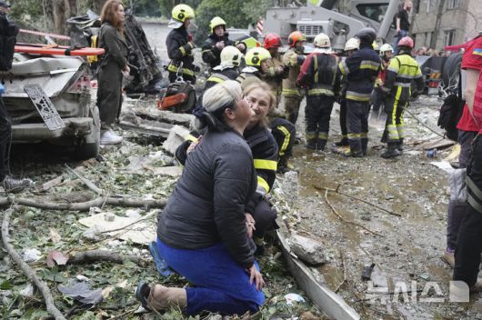 [키이우=AP/뉴시스] 31일(현지 시간) 우크라이나 키이우에서 한 구조대원이 밤사이 발생한 러시아의 미사일 공격 현장에서 흐느끼는 주민을 위로하고 있다. 2025.07.31.