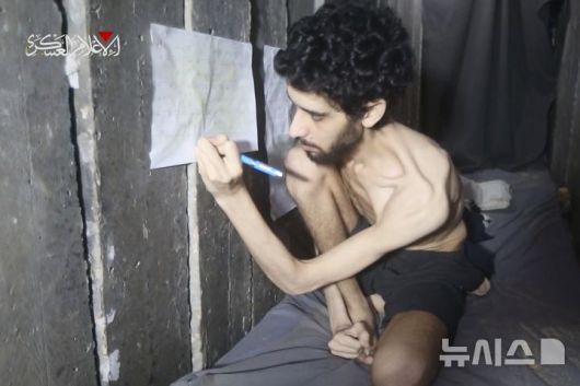 [가자지구=AP/뉴시스] 팔레스타인 무장단체 하마스가 지난 1일(현지 시간) 공개한 촬영 날짜 미상의 영상에서 이스라엘 인질 에바아타르 데이비드(24)가 본인이 억류된 가자지구 지하 터널 안에서 달력에 받은 음식을 표시하고 있다. 데이비드는 2023년 10월 7일 하마스의 기습 당시 납치됐다. 2025.08.05.