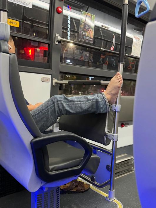 [뉴시스] 버스에서 한 남성이 손잡이 봉에 다리를 올린 모습. (출처=보배드림) *재판매 및 DB 금지