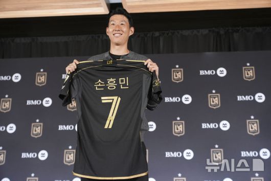 [로스앤젤레스=AP/뉴시스] 손흥민이 6일(현지 시간) 미 캘리포니아주 로스앤젤레스(LA)의 BMO 스타디움에서 열린 미국프로축구(MLS) LA FC 입단 기자회견에서 본인의 등번호 7번이 새겨진 유니폼을 들고 포즈를 취하고 있다. 2025.08.07.