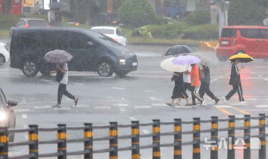 [제주=뉴시스] 우장호 기자 = 정체전선 영향으로 호우특보가 내려진 11일 오전 제주시 노형오거리 인근 거리에 우산을 쓴 시민들이 걸어가고 있다. 2025.08.11. woo1223@newsis.com