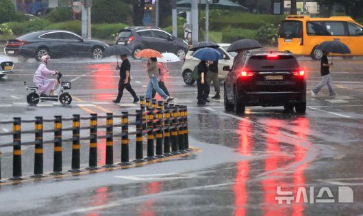 [제주=뉴시스] 우장호 기자 = 정체전선 영향으로 호우특보가 내려진 11일 오전 제주시 노형오거리 인근 거리에 우산을 쓴 시민들이 걸어가고 있다. 2025.08.11. woo1223@newsis.com
