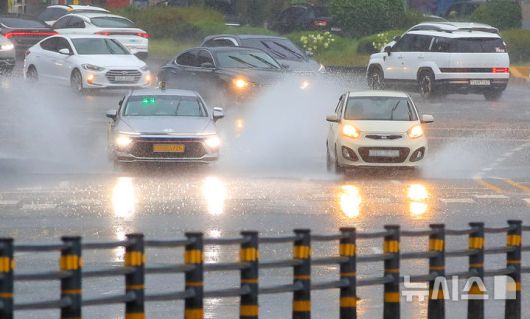 [제주=뉴시스] 우장호 기자 = 정체전선 영향으로 호우특보가 내려진 11일 오전 제주시 노형오거리 인근 거리에서 차량들이 물보라를 일으키며 지나가고 있다. 2025.08.11. woo1223@newsis.com