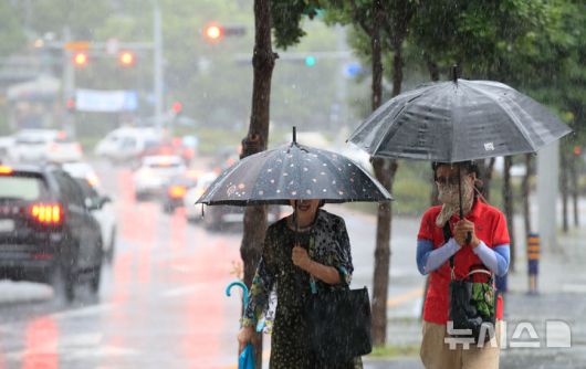 [제주=뉴시스] 우장호 기자 = 정체전선 영향으로 호우특보가 내려진 11일 오전 제주시 노형오거리 인근 거리에 우산을 쓴 시민들이 걸어가고 있다. 2025.08.11. woo1223@newsis.com