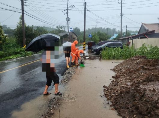[군산=뉴시스] 26일 전북 군산시 회현면의 한 도로에서 호우로 인해 하수구가 막혀 물이 고이자 소방대원들이 조치에 나서고 있다. (사진=전북도소방본부 제공) 2025.08.26. photo@newsis.com *재판매 및 DB 금지