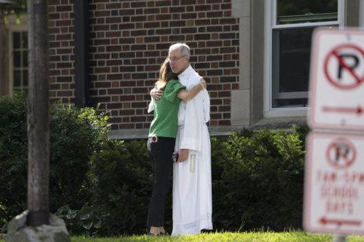 [미니애폴리스=AP/뉴시스] 27일(현지 시간) 총격 사건이 발생한 미국 미네소타 미니애폴리스 수태고지 성당에서 성직자와 신도가 희생자를 애도하며 위로하고 있다. 2025.08.28.