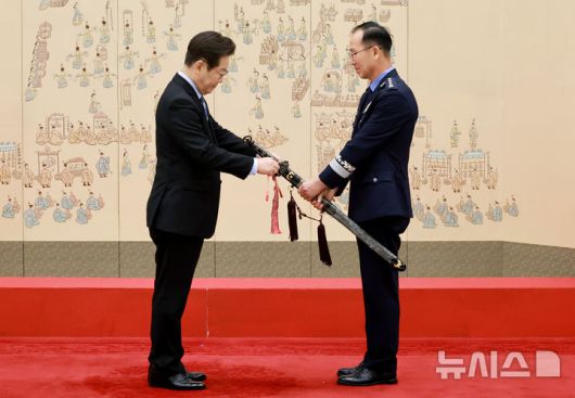 [서울=뉴시스] 최동준 기자 = 이재명 대통령이 2일 서울 용산 대통령실 청사에서 열린 대장 진급·보직 신고 및 삼정검 수치 수여식에서 손석락 공군참모총장의 삼정검에 수치를 달아주고 있다. (대통령실통신사진기자단) 2025.09.02. photocdj@newsis.com