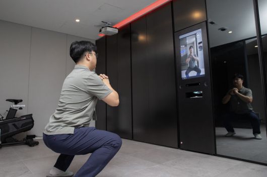 [서울=뉴시스] 현대건설 관계자가 마북기술연구원 '올라이프케어하우스' 내에 있는 '웰니스(Wellness) 솔루션' 중 운동 기능을 직접 시연하는 모습. 2025.09.07. (사진=현대건설 제공) photo@newsis.com  *재판매 및 DB 금지