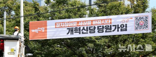 [대구=뉴시스] 이무열 기자 = 이준석 개혁신당 대표가 5일 대구 북구 경북대학교 북문 앞에서 정당 가입 독려 현수막을 직접 게첩하고 있다. 2025.09.05. lmy@newsis.com