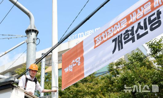 [대구=뉴시스] 이무열 기자 = 이준석 개혁신당 대표가 5일 대구 북구 경북대학교 북문 앞에서 정당 가입 독려 현수막을 직접 게첩하고 있다. 2025.09.05. lmy@newsis.com