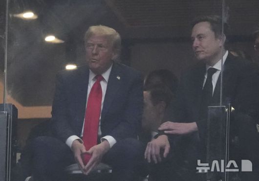 [글렌데일=AP/뉴시스] 도널드 트럼프 미국 대통령이 21일(현지 시간) 애리조나주 글렌데일 스테이트팜 스타디움에서 열린 보수 성향 활동가 찰리 커크 추모 행사에 참석해 일론 머스크 테슬라 최고 경영자와 얘기하고 있다. 2025.09.22.