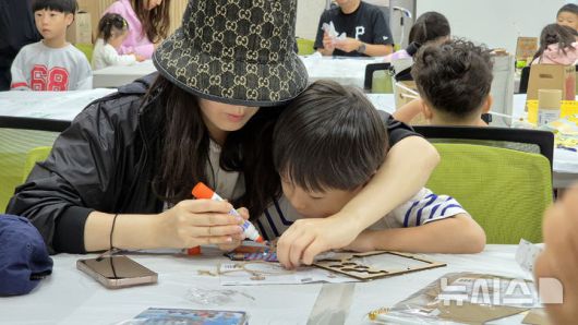 [청주=뉴시스] 연현철 기자 = 추석 연휴 첫날이자 개천절인 3일 충북 청주시 상당구 국립청주박물관에서 엄마와 아이가 키트를 활용한 전통집 만들기 체험을 하고 있다. 2025.10.03. yeon0829@newsis.com