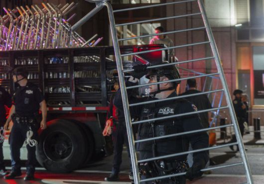 [뉴욕=AP/뉴시스] 10월 21일 미국 뉴욕에서 이민자 단속 이후 시위가 발생해 한 경찰관이 바리케이드를 운반하고 있다. 설상가상으로 주말인 11월 1일부터 전국의 저소득층 식품지원금이 셧다운으로 끊길 예정이다. 2025.10.28.