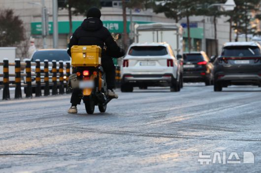 [서울=뉴시스] 권창회 기자 = 폭설 후 한파로 도로 곳곳이 얼어붙은 5일 오전 서울 중구 충무로역 인근에서 오토바이 운전자가 서행하고 있다. 2025.12.05. kch0523@newsis.com