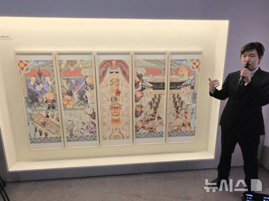 [서울=뉴시스]오동현 기자 = 조길현 데브시스터즈 대표가 8일 서울 중구 덕수궁 돈덕전에서 '쿠키런: 사라진 국가유산을 찾아서' 특별전 기자간담회를 열고 다섯 폭 병풍 형식의 '쿠키런 상상화 2: 칭경예식, 새 시대를 열다'를 소개하고 있다. 2025.12.08. odong85@newsis.com