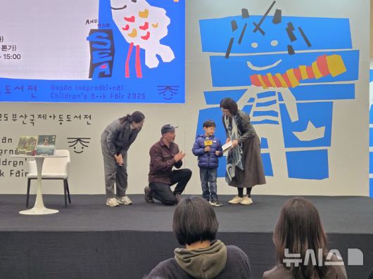 [부산=뉴시스] 조기용 기자 = 13일 부산 벡스코 제1전시장 3홀에서 열린 2025 부산국제아동도서전의 대담 '바다처럼 살아가는 어린이들에게'에 캐나다 대표 작가 조던 스콧이 대담에 참석한 어린이 독자를 만나고 있다. 2025.12.13. excuseme@newsis.com