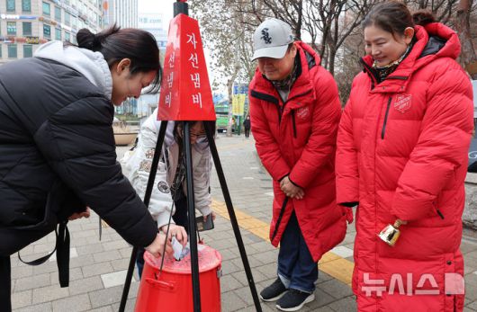 [인천=뉴시스] 전진환 기자 = 16일 오후 인천 미추홀구 롯데백화점 앞 사거리에서 학생들이 구세군 자선냄비에 성금을 넣고 있다. 2025.12.16. amin2@newsis.com