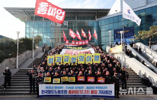 [서울=뉴시스] 조성우 기자 = 양경수 민주노총 위원장과 전국철도노동조합 조합원들이 19일 오후 서울 중구 서울역 광장에서 열린 총파업 돌입 기자회견에서 구호를 외치고 있다. 철도노조는 정부의 '성과급 정상화' 합의 파기를 규탄하고, 정부의 입장 변화가 없을 경우 오는 23일 오전 9시부터 총파업에 돌입하겠다고 밝혔다. 2025.12.19. xconfind@newsis.com